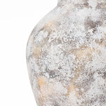 Close-up of a textured, weathered ceramic vase with a speckled pattern in white, gray, and hints of brown. This stunning piece is perfect for adding elegance to your home decor with its unique design reminiscent of white marble texture.