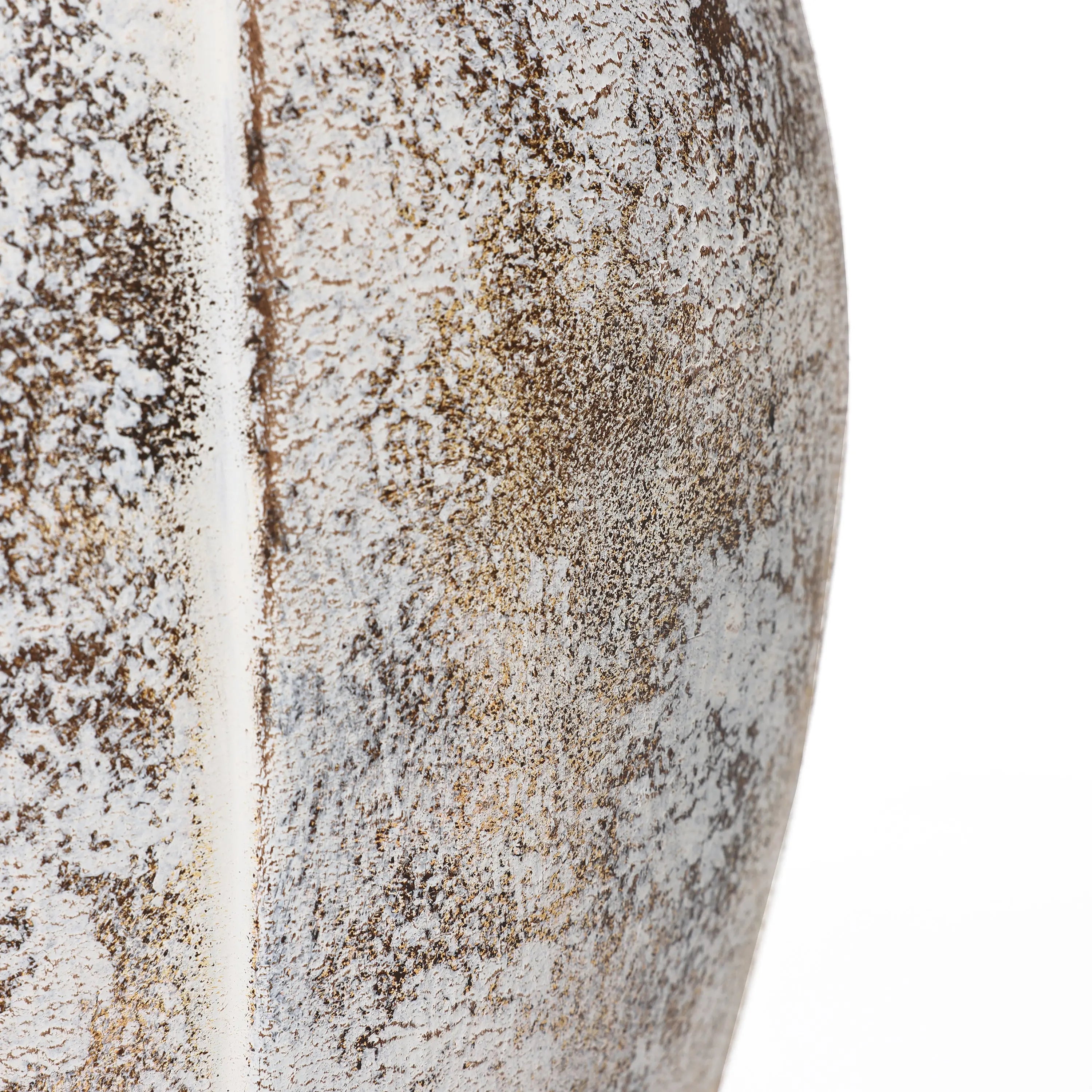 Close-up of a textured surface with speckles of brown and white, reminiscent of a broken egg design, showing a slightly curved line running vertically through the middle.