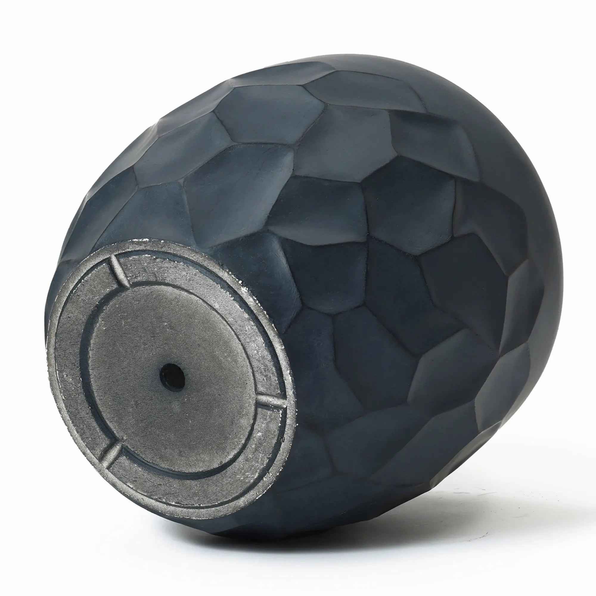 Close-up of a dark, textured vase lying on its side, crafted from durable magnesium oxide material. The geometric pot planter design highlights a rounded base with a small central hole, suitable for both indoor and outdoor use.