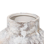 Close-up of a weathered, white and brown ceramic vases round opening and textured surface, perfect for elevating your home decor with its artistic charm.