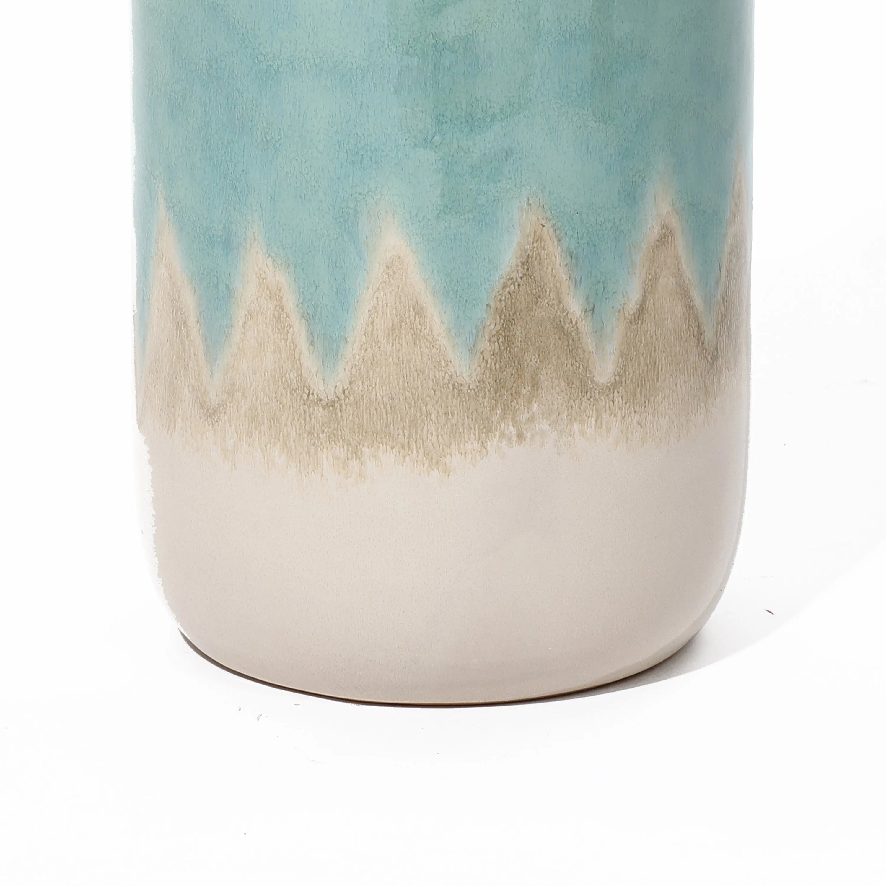 A close-up of a coastal-inspired vase showcases a zigzag pattern near the top, with blue and beige hues on a light background. Perfect as tabletop decor, this ceramic piece adds nautical charm to any setting.
