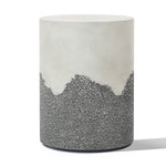 A cylindrical stool with a smooth white upper section and a textured gray lower section, resembling a cement side table.