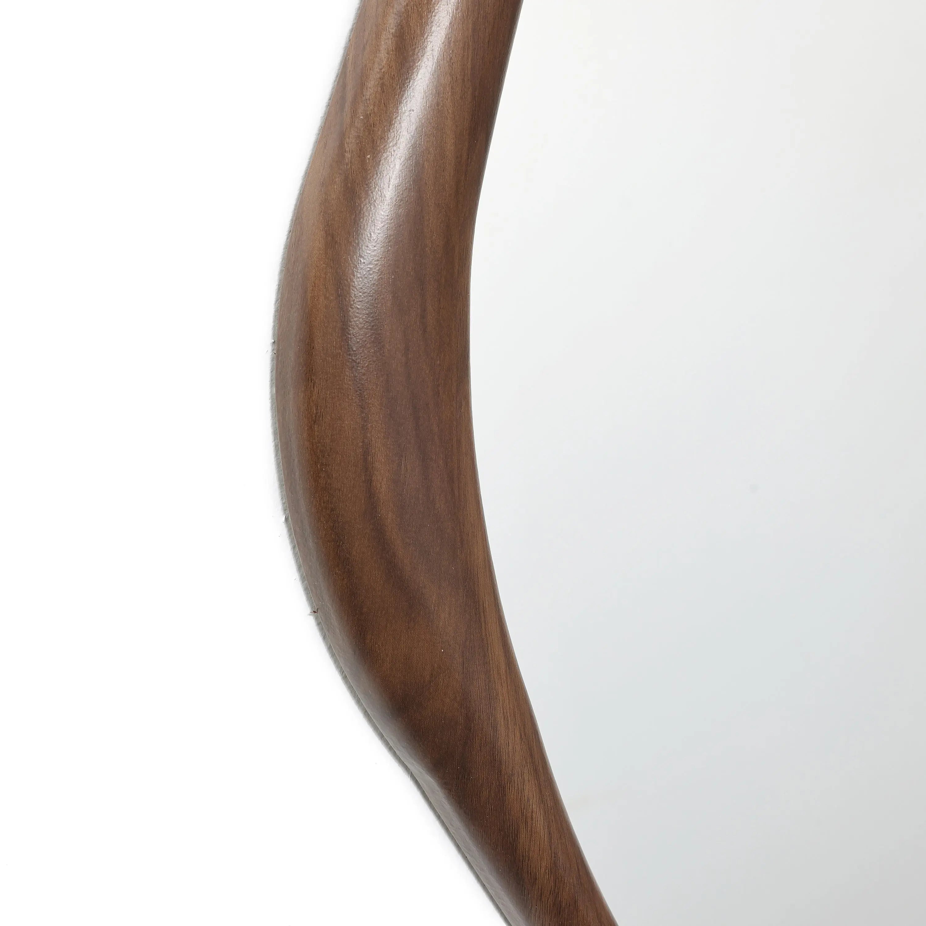 Close-up of a wooden edge of a wall mirror, exuding Scandinavian charm. The wood boasts a smooth, polished finish with a natural grain pattern, embodying minimalist design.