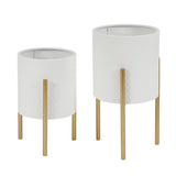 Two white metal planters with textured surfaces, each elevated on three gold legs of different heights, showcase a contemporary modern style and minimalist design against a plain background.
