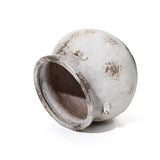 The LuxenHome Antique cauldron planter lies on its side, offering a vintage rustic look with an earthy, patchy clay texture in brown and gray. The round design includes a wide open mouth and small handles for added charm.