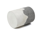 A cylindrical object with a smooth white surface on one half and a rough, textured grey surface on the other, reminiscent of an ombre style finish, is displayed against a plain white background.