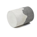 A cylindrical object with a smooth white surface on one half and a rough, textured grey surface on the other, reminiscent of an ombre style finish, is displayed against a plain white background.
