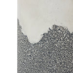 Close-up of a wall with peeling paint and exposed rough concrete, showcasing an ombre style finish. The top half is smooth and beige, while the bottom half reveals a textured gray surface reminiscent of the weathered look youd find on an outdoor seating area.