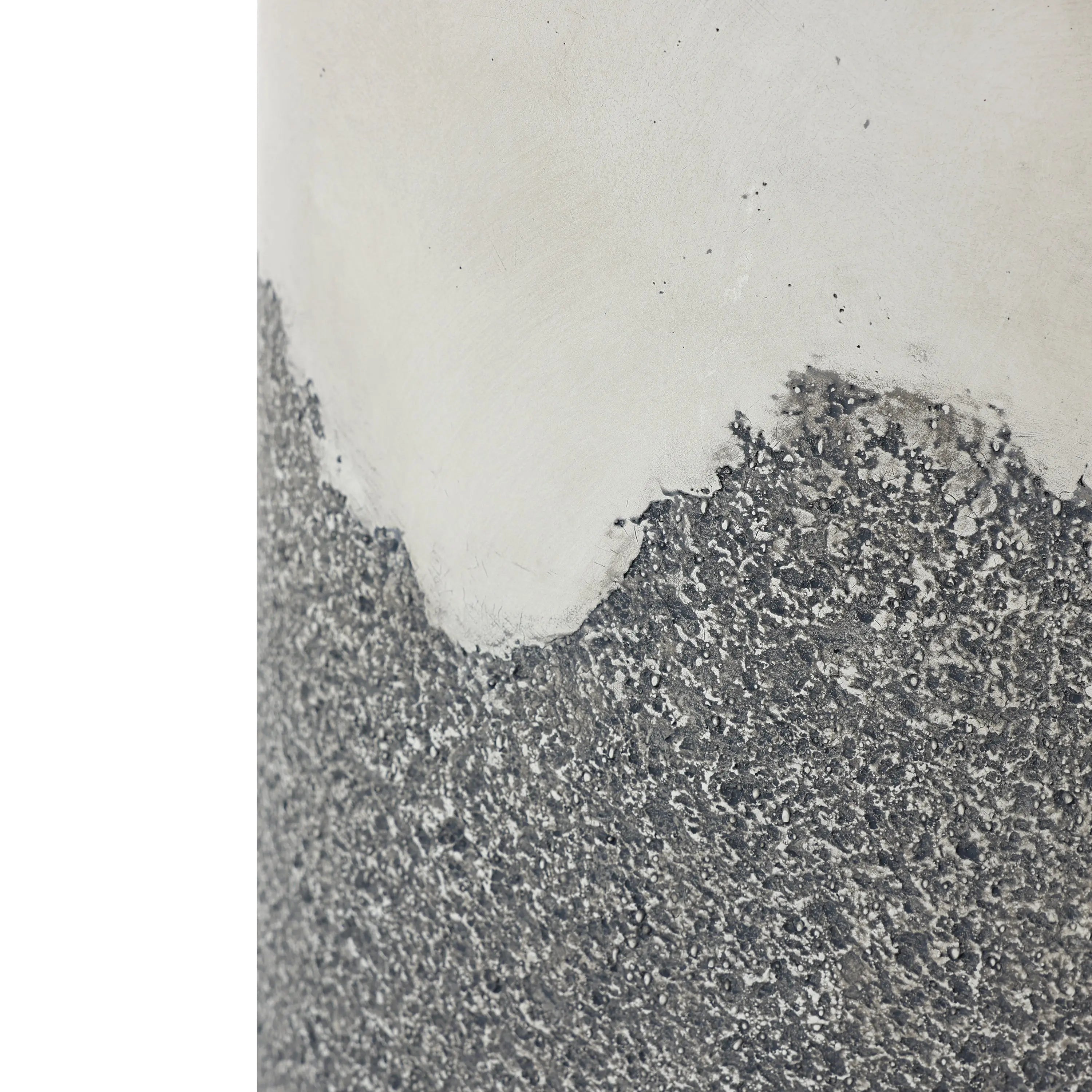 Close-up of a wall with peeling paint and exposed rough concrete, showcasing an ombre style finish. The top half is smooth and beige, while the bottom half reveals a textured gray surface reminiscent of the weathered look youd find on an outdoor seating area.