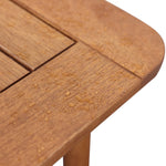 Close-up of a solid Malaysian hardwood table corner, with raindrops elegantly dotting the surface, showcasing its readiness as an outdoor dining table.