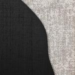 Close-up of a textured surface showcasing geometric shapes, with a curved black area meeting a white, speckled section, creating an abstract wall art pattern.