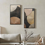 Two abstract wall decor art pieces featuring circular patterns in gold and black, with intricate embossed textures, are elegantly hung above a beige sofa. A small vase sits on a side table, adding a touch of charm to the scene.