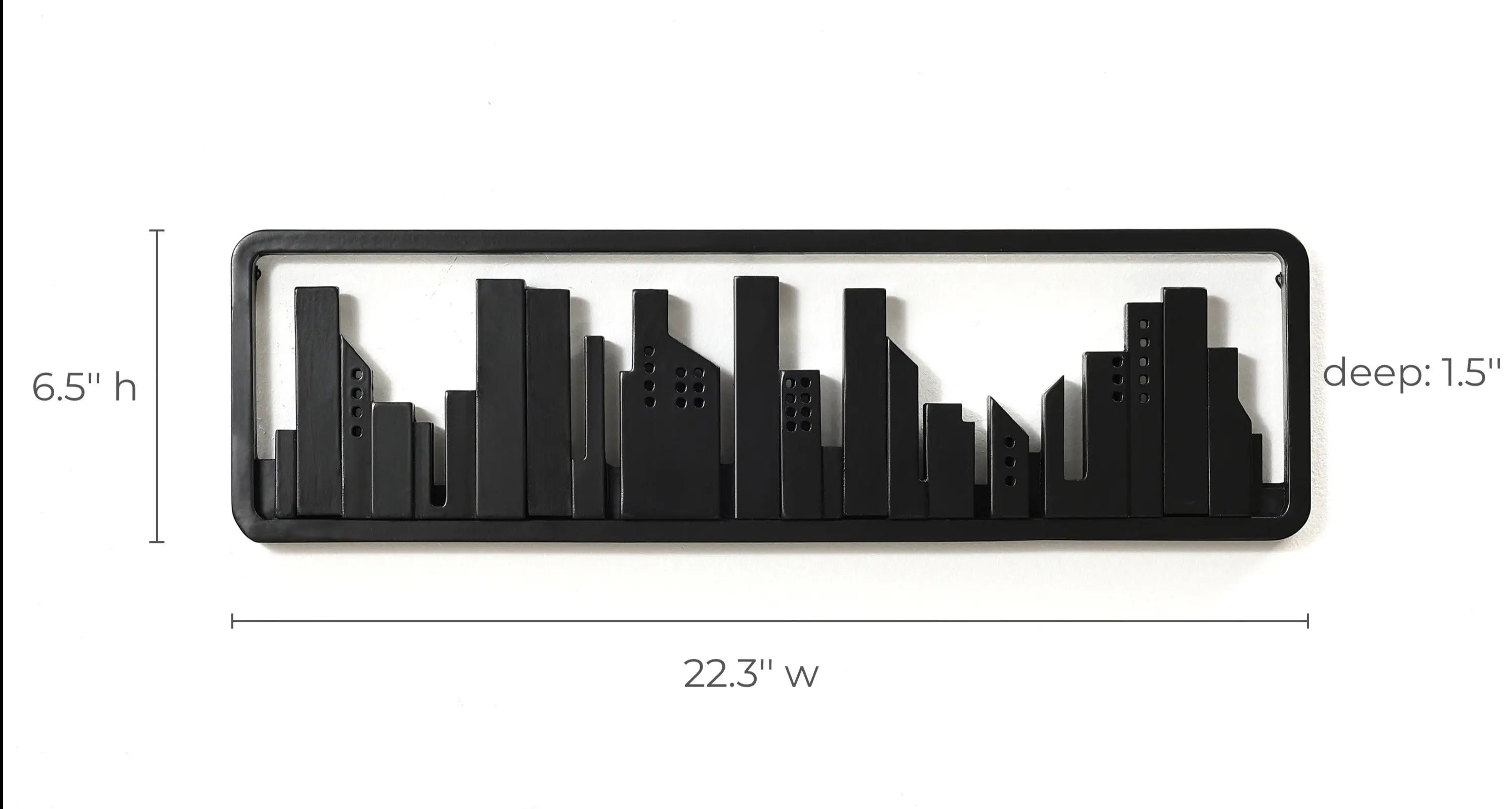 A black, rectangular metal wall art piece featuring a city skyline silhouette, measuring 22.3 inches wide, 6.5 inches high, and 1.5 inches deep, cleverly integrates flip-down hooks to double as a chic wall-mounted coat rack.
.