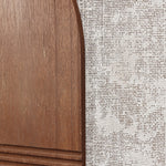 Close-up of a wooden surface with a curved edge paired elegantly with textured, woven fabric, reminiscent of abstract wall art.