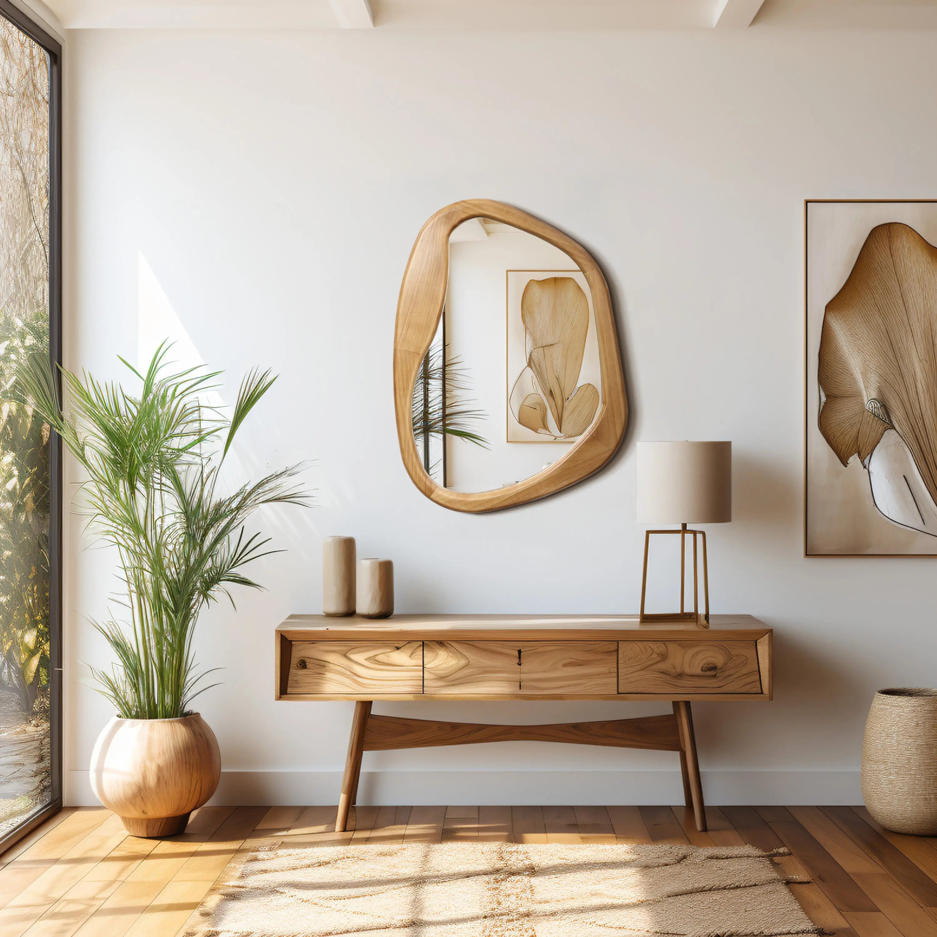 A modern, minimalist room showcases organic decor with a wooden console table adorned with vases, a mirror, framed artwork, and a floor plant. A natural ambiance fills the space as light streams in through a large window, highlighting the table lamps subtle glow.