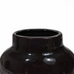 Close-up of a vintage ceramic vase with a glossy, black surface and a wide, round opening. Its smooth, reflective finish adds an elegant touch to home decor, creating a striking centerpiece when paired with color block gradient designs.