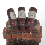 Three brown glass bottles are positioned upside down on a brick structure, with soothing water sounds flowing from their openings into a container below.
