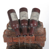 Three brown glass bottles are positioned upside down on a brick structure, with soothing water sounds flowing from their openings into a container below.