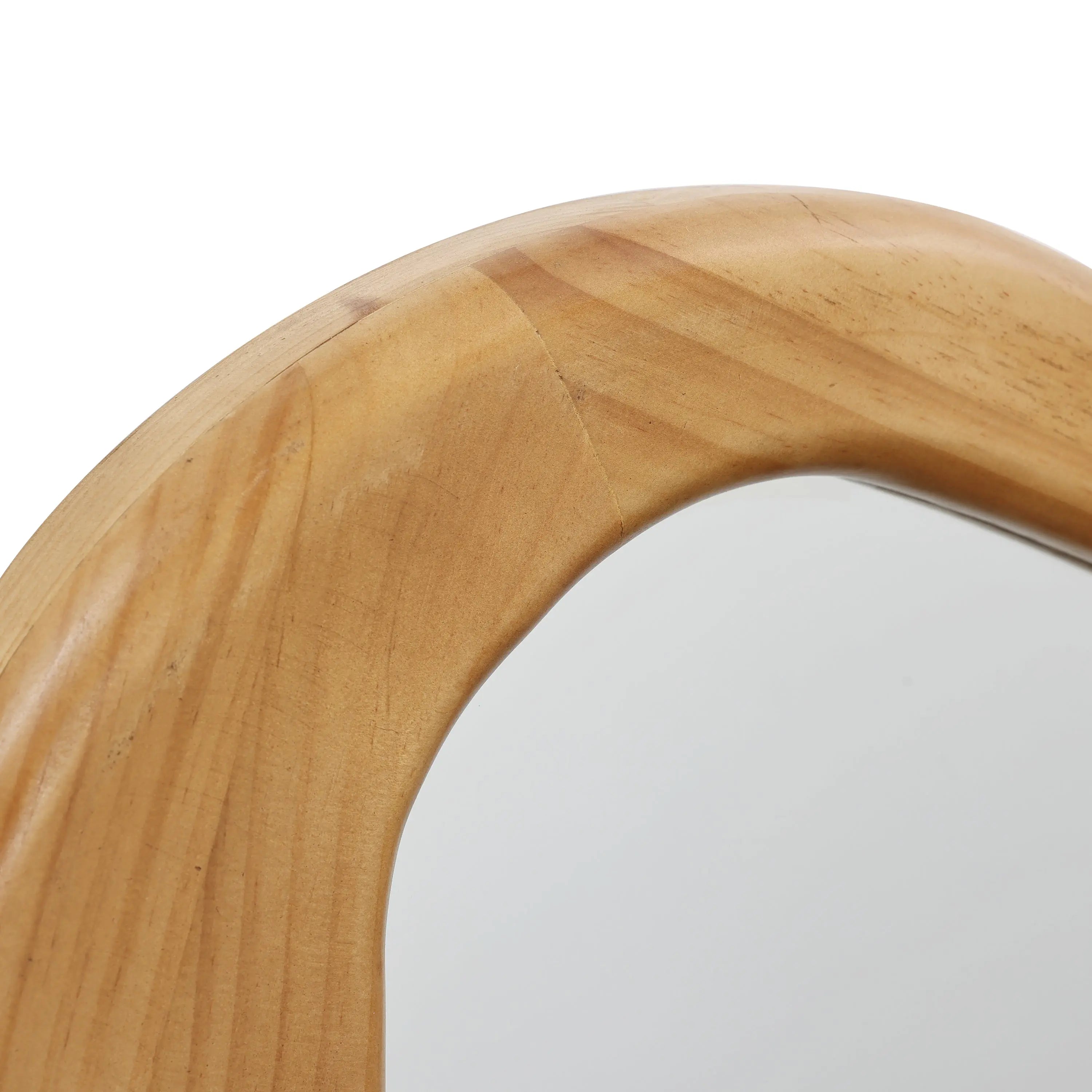 Close-up of a curved, wooden-framed mirror with a smooth, light-colored finish, adding an organic touch to any decor.