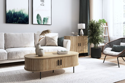 living room set up, ivory color vases set on top of wood accent coffee table in front of sectional sofa, sliding door accent cabinet at the back with black planters and wood accent chair by the side