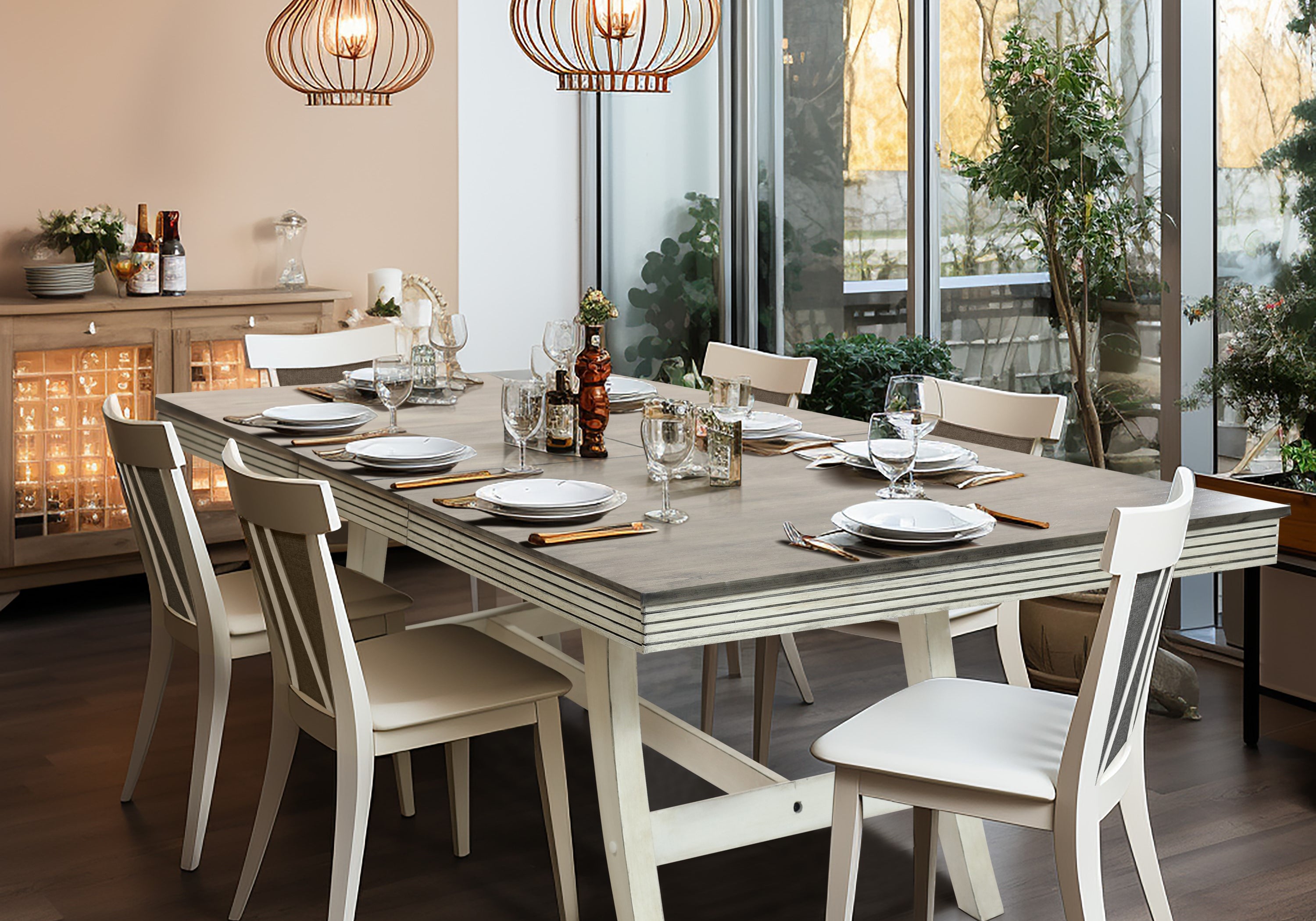 Modern dining room with a wooden table set for six, featuring white chairs, pendant lights, and a sideboard. Large windows provide natural light and greenery is visible outside.