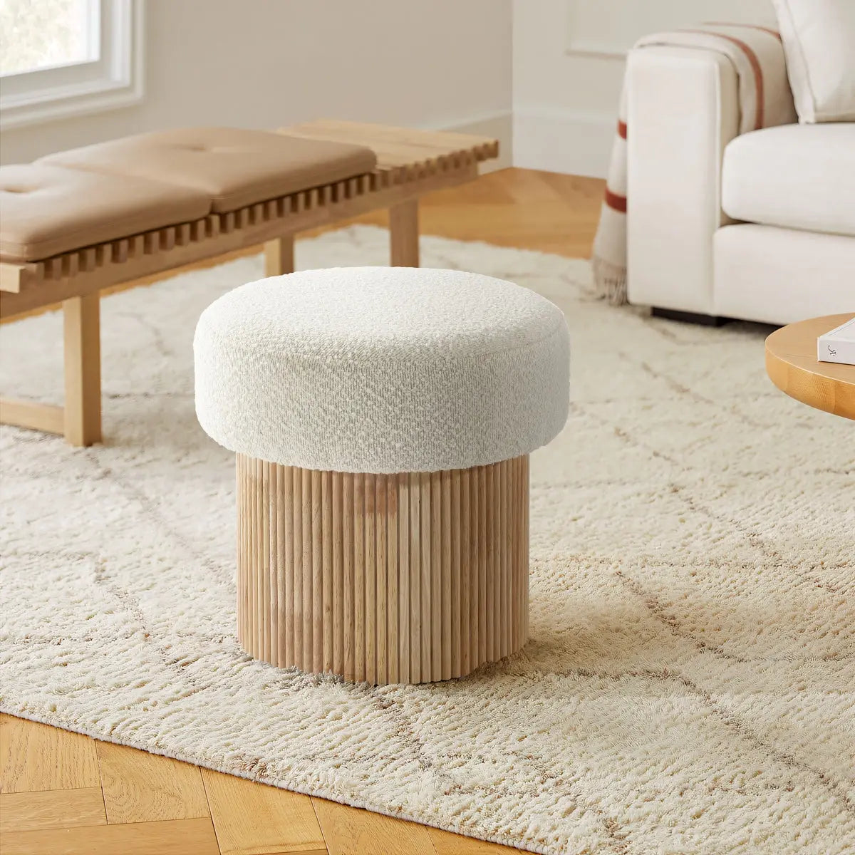 flued-wood-base-boucle-ottoman-in-warm-living-room