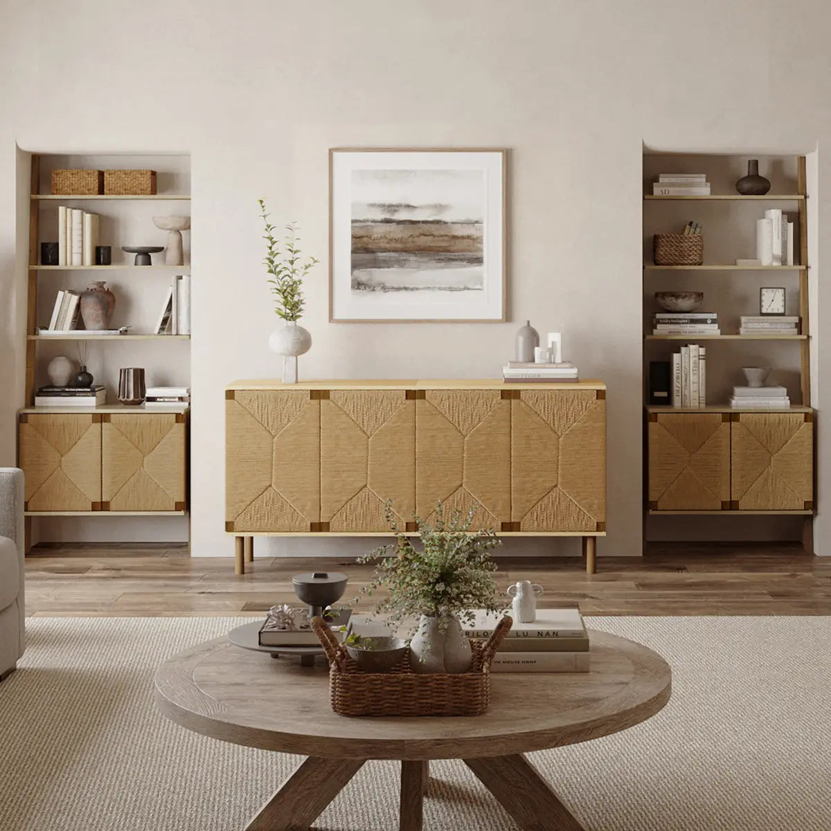 Minimalist living room with a round wooden coffee table and plants. A textured sideboard is flanked by built-in shelves filled with decor items. Neutral tones throughout.