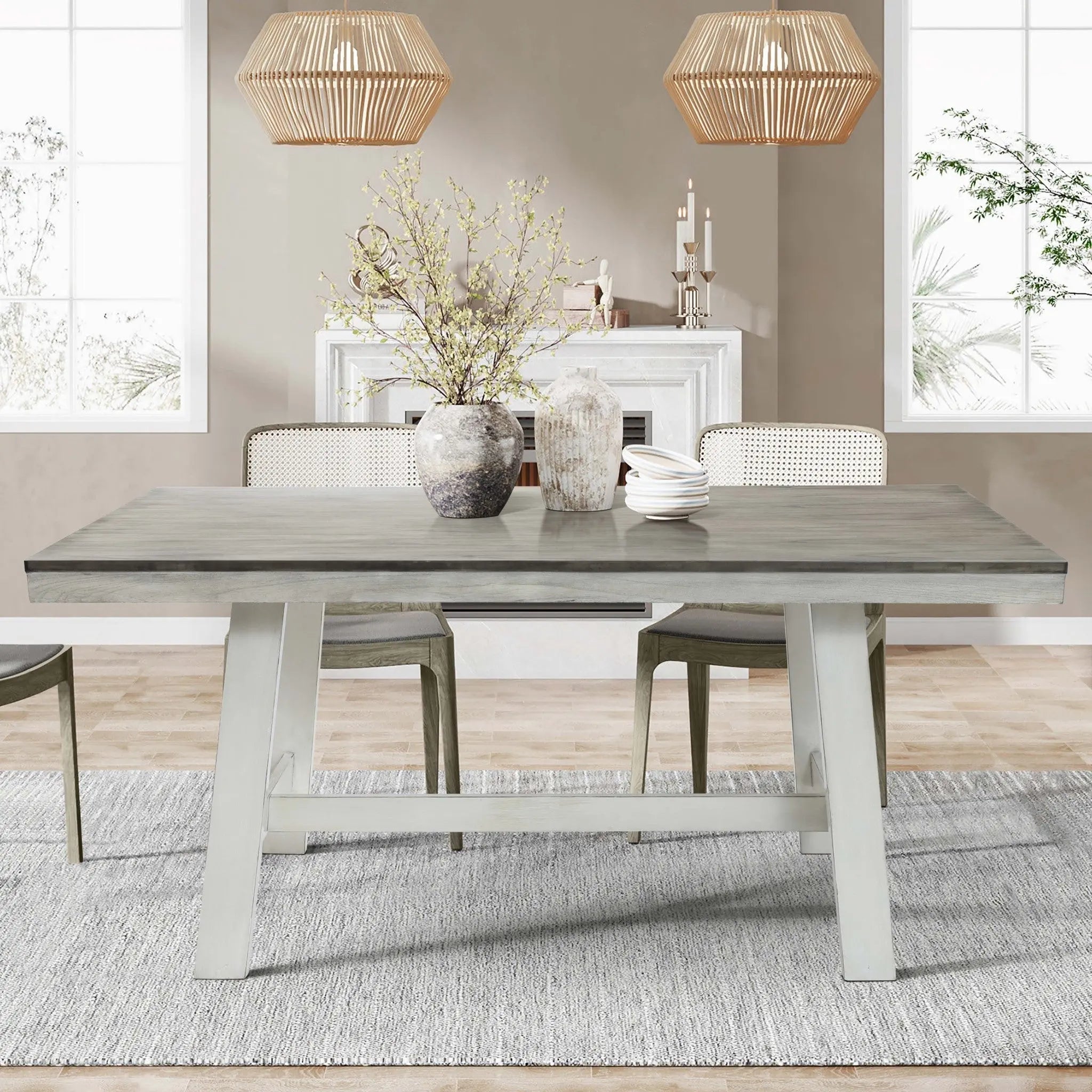 A dining room with a wooden table, chairs, potted plants, and decorative vases. Natural light enters through large windows. Two pendant lights hang above, and a textured rug covers the floor.