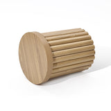 An oak finish wooden stool with a fluted drum design lies elegantly on its side against a plain white background.