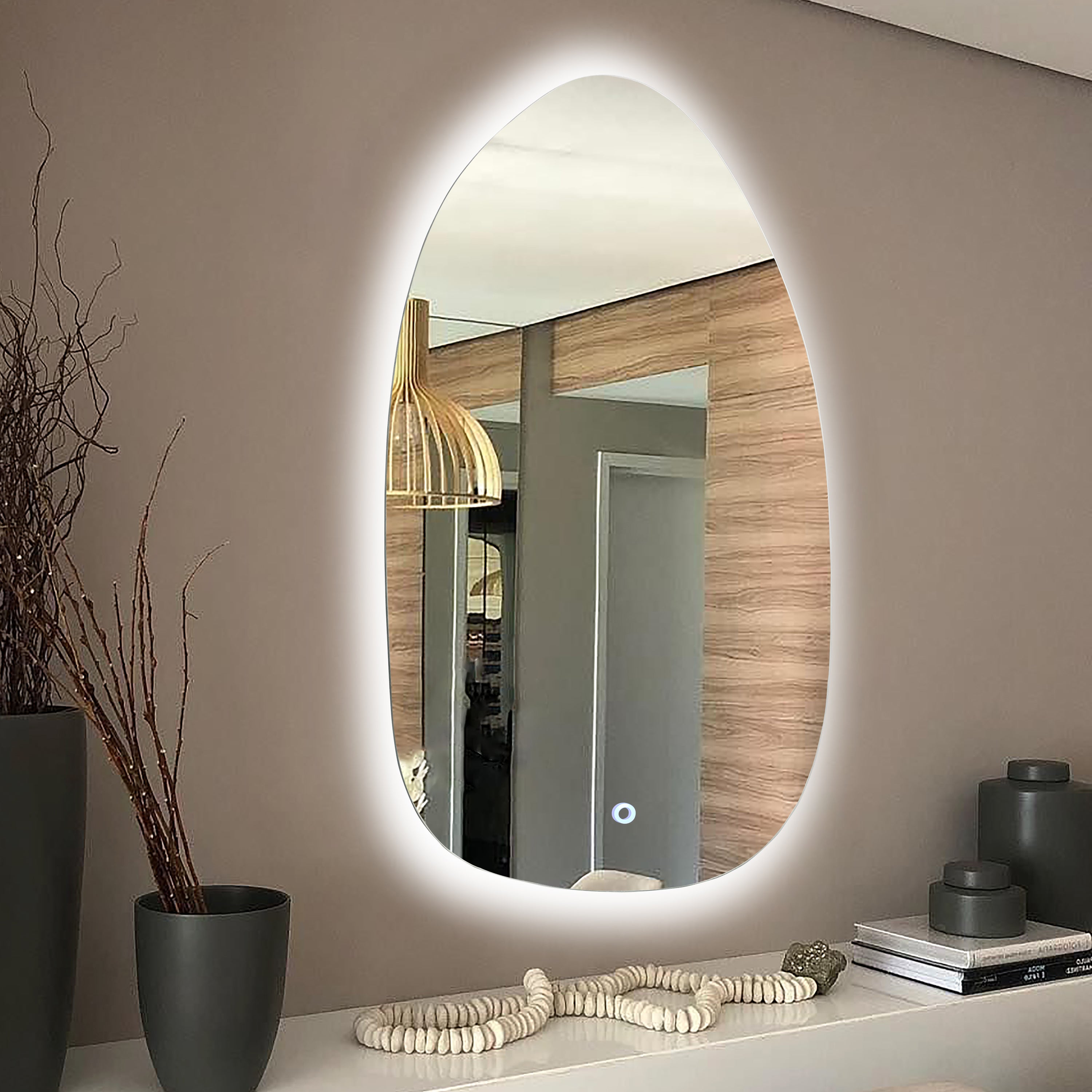 backlit decorative mirror above a console table in an entryway