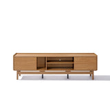 The Eric TV stand from LuxenHome features a minimalist, mid-century modern design with a light oak finish. Accommodating up to a 75-inch TV, it offers two closed side compartments and two central open shelves, elegantly supported by slim black legs against a plain white backdrop.