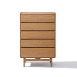 The Eric oak finish 5-drawer chest by LuxenHome features a Mid-Century Modern minimalist design and stands on small legs, creating a gentle shadow.