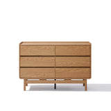 The LuxenHome Eric oak finish 6-drawer dresser showcases a Mid-Century Modern style with its light brown walnut wood, minimalist design, and sleek horizontal drawers without visible handles, elegantly resting on four legs against a plain white background.