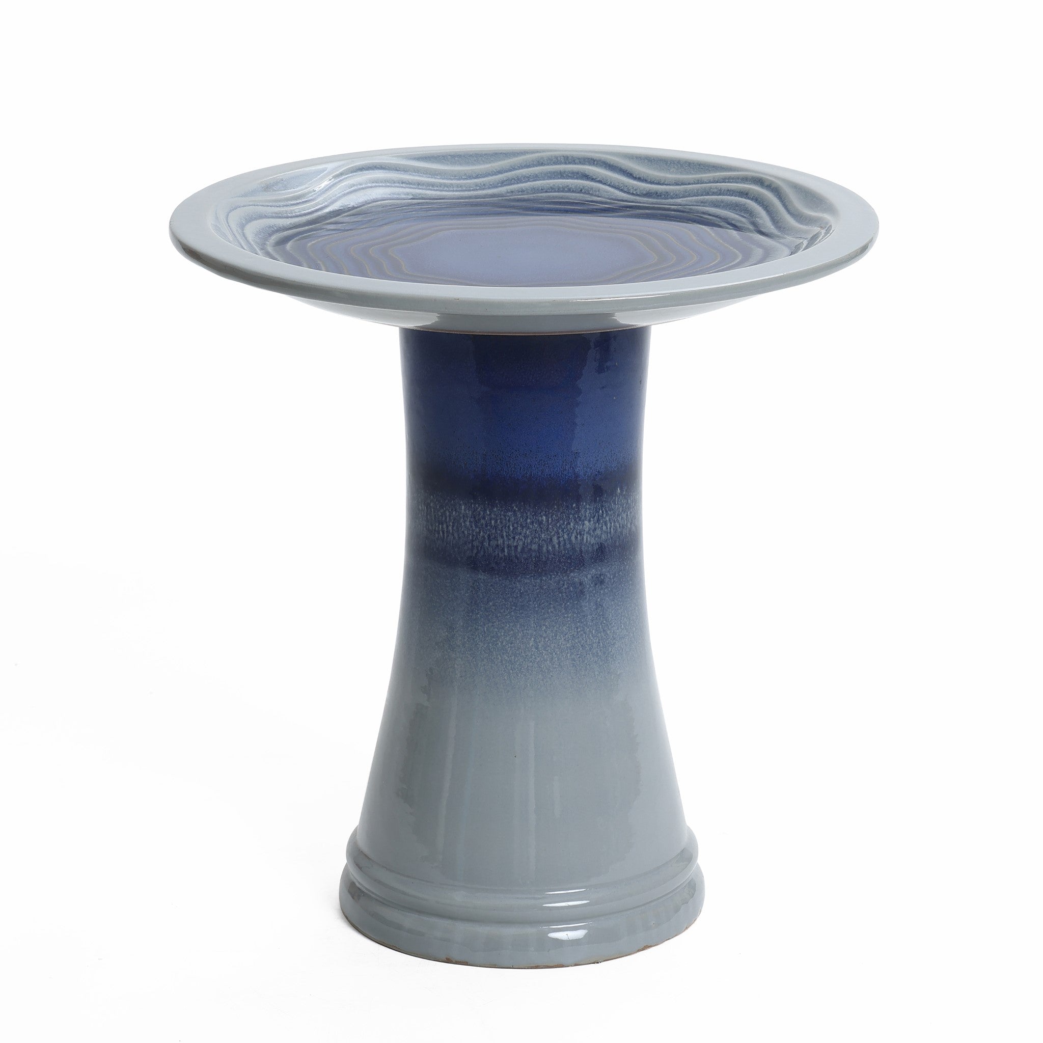 A glazed outdoor bird bath featuring a ceramic, round, textured basin set atop a tapered blue and gray pedestal.