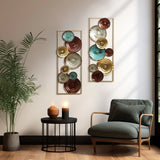 A cozy corner featuring a modern chair, round side table with decor, and abstract metal wall decor with circular patterns in warm tones. A potted plant is positioned next to the chair.