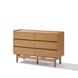 The LuxenHome Eric oak finish dresser, featuring a minimalist design inspired by Mid-Century Modern style, includes six drawers and stands on short legs against a plain white background.