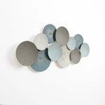 A stunning abstract wall art installation featuring overlapping textured circles in shades of gray and blue, mounted on a white background, evokes a vintage metal wall decoration feel with its exquisite design. This multi-color wall decor piece adds depth and elegance to any space.
