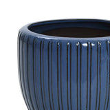 Close-up of a dark blue ceramic flowerpot showcasing a three-dimensional vertical pattern and a glossy finish.