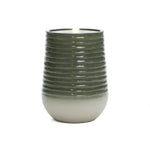 Green and white ceramic cup with a ribbed design, housing a lit candle inside.