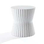 The Speckled White Fluted Hourglass Outdoor Side Table, crafted from MgO material, stands against a plain white background. Its cylindrical design showcases textured, vertical grooves, lending it a modern and sculptural appeal.