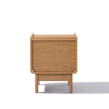 The Eric oak finish nightstand with drawer by LuxenHome exudes mid-century elegance. Crafted from summer oak engineered wood, it features straight lines and a natural wood finish, all presented against a plain white background with a subtle shadow.