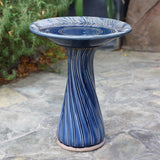 Blue ceramic birdbath with leaves and swirl pattern