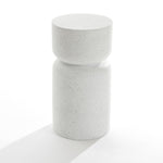 The Speckled White Pillar Outdoor Side Table boasts a minimalist cylindrical design with light gray terrazzo. Its contemporary flair comes from a wider top and narrow middle, resembling a chic stool. Set against a plain white background, it highlights elegant simplicity.