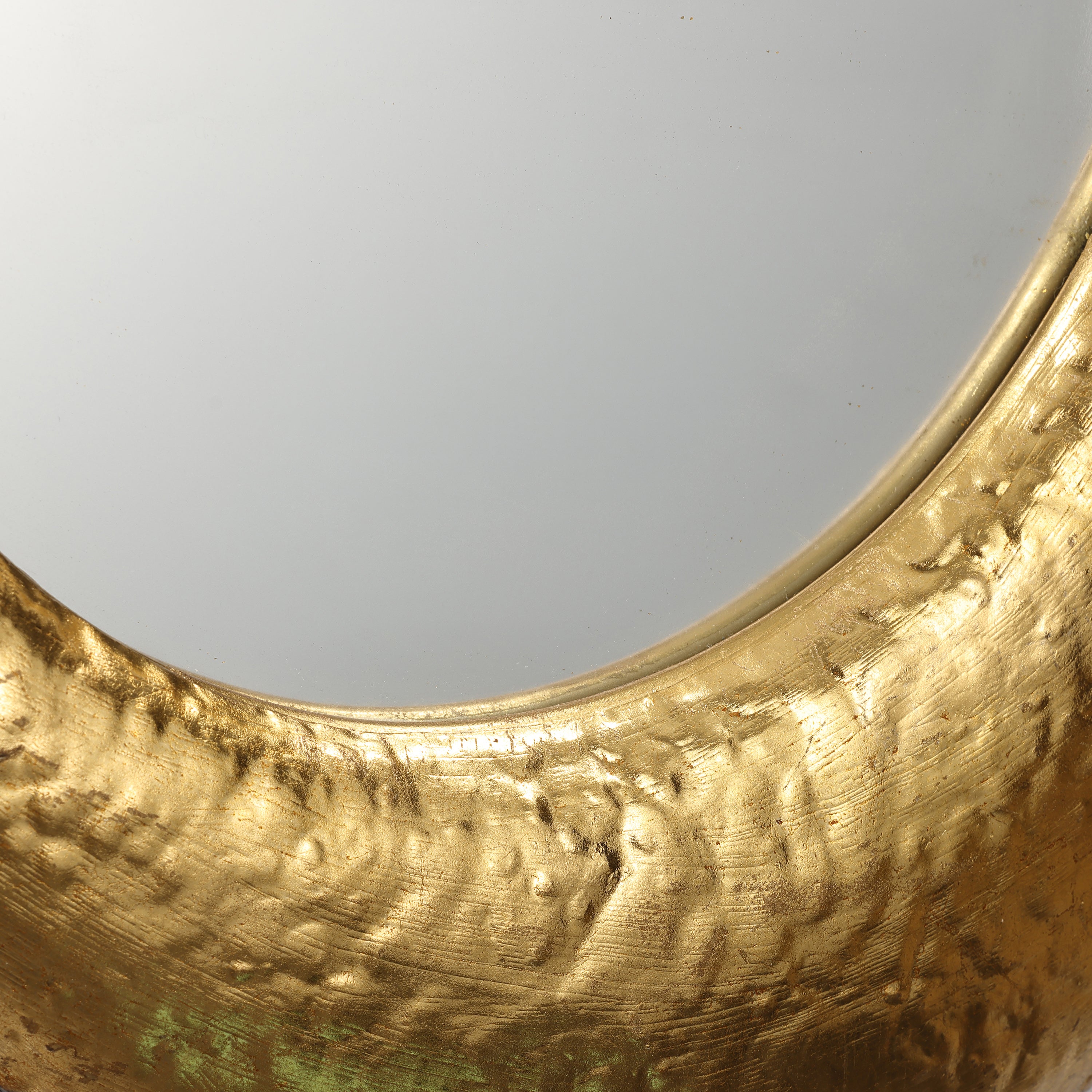 close up to the junction of gold color metal frame and high-gloss mirror panel of a wall mirror