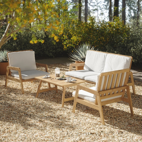 solid wood frame, white cushioned outdoor patio conversation set, for 4 person, 2 armchairs, 1 loveseat, 1 coffee table, place on gravel surface in a california style coastal backyard