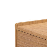 Close-up of the Eric oak finish 70 TV stand by LuxenHome reveals smooth edges and natural wood grain. The light brown finish and minimalistic design create a modern, elegant aesthetic, making it an ideal piece for any mid-century modern setup. Suitable for TVs up to 75.