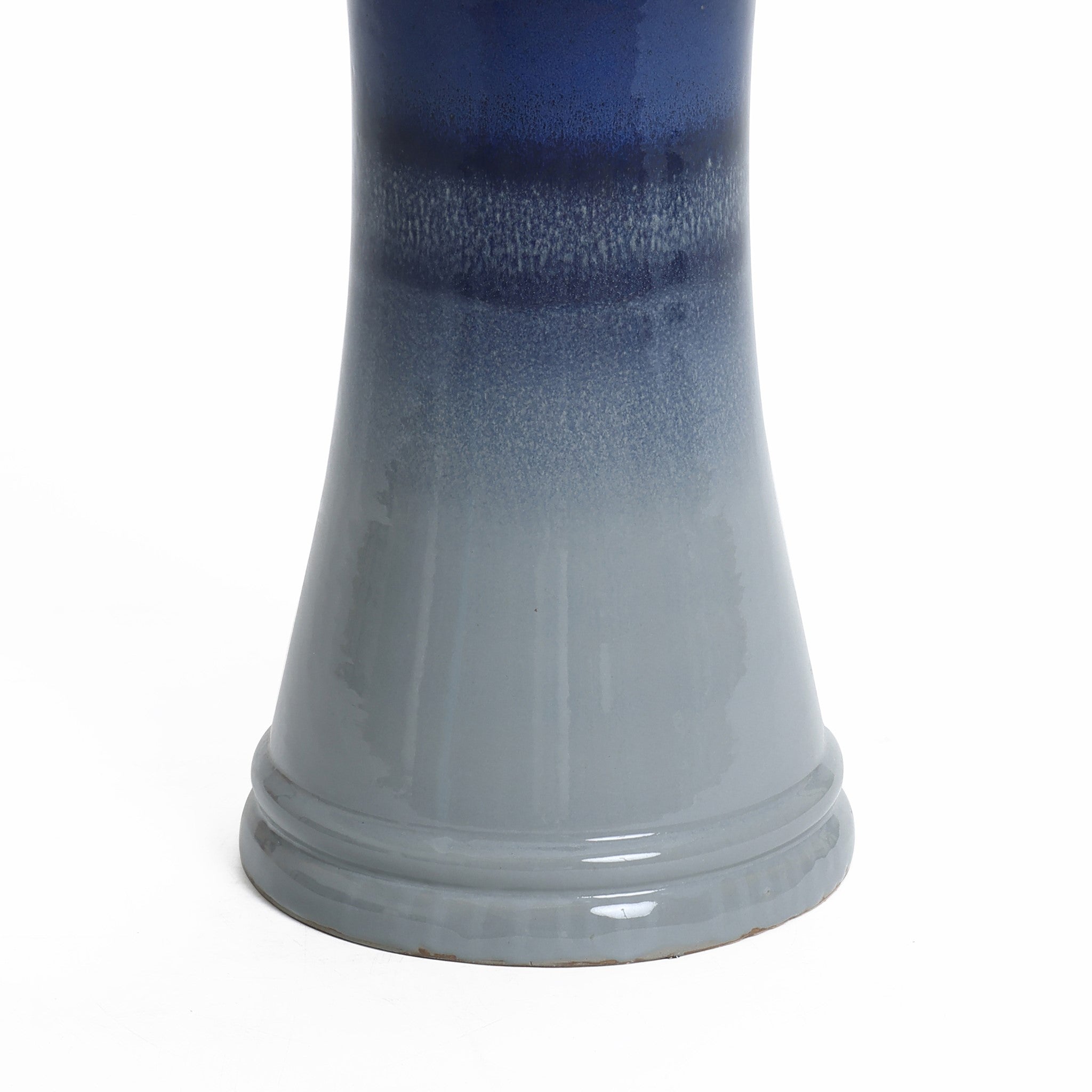 The image shows the bottom half of a blue and gray ceramic vase with a glossy finish, reminiscent of an artistically crafted glazed bird bath.