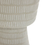 A close-up of a gray textured ceramic vase crafted from magnesium oxide, featuring vertical lines. Its rounded top and narrower base exhibit a minimalist design ideal for pairing with the LuxenHome Meru outdoor end/side table in beige.