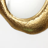 edge close-up of a gold color metal frame wall mirror showing the shiny accent and thickness of the edge