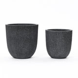 Two black textured cylindrical planters of different sizes, crafted from durable polyethylene, are placed side by side on a white background.